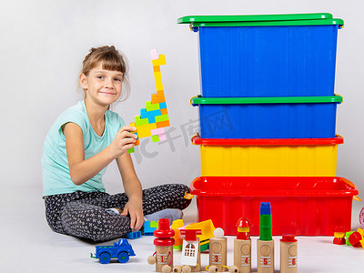 玩玩具的女孩，大塑料盒站在附近