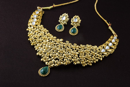 印度传统珠宝，深色背景中吊坠和耳环的特写