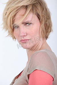 头发凌乱的 50 岁女性看起来很生气或遇到麻烦