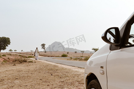 村民摄影照片_在炎热的夏日里，中年贫穷的印度村民独自走在空荡荡的道路上。