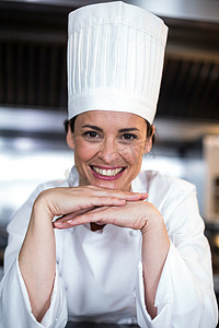 帽托摄影照片_手托下巴的快乐女厨师画像