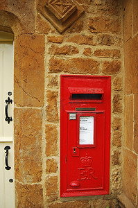 在石墙上的红色英国邮箱