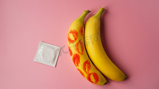 避孕套和两根香蕉，上面有红色唇膏的痕迹，避孕药的概念