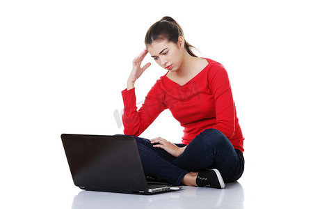 悲伤的女人摄影照片_悲伤的女人在笔记本电脑屏幕上看。