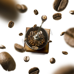 咖啡机和咖啡豆摄影照片_白色背景中飞行的咖啡研磨机和咖啡豆