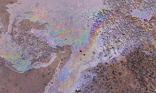 沥青上的油渍、沥青路上的彩色汽油燃料斑点作为纹理或背景