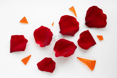 红色花瓣碎片摄影照片_红色玫瑰花瓣和橙色玻璃碎片