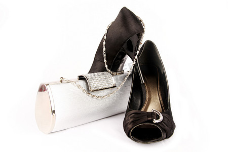 黑色高跟鞋女鞋和白色背景上的银色手拿包。