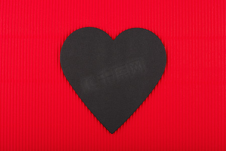 在红色瓦楞纸背景的黑纸心脏与小肚。