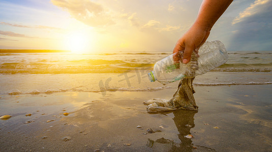 手在沙滩上捡垃圾，环保理念