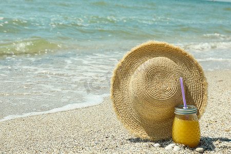 文字夏天摄影照片_海边的草帽和橙汁，文字空间。
