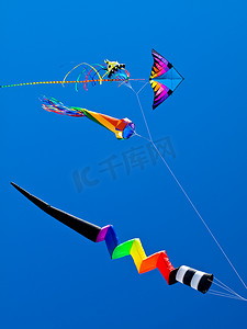 各种色彩缤纷的风筝在明亮的蓝天中飞翔