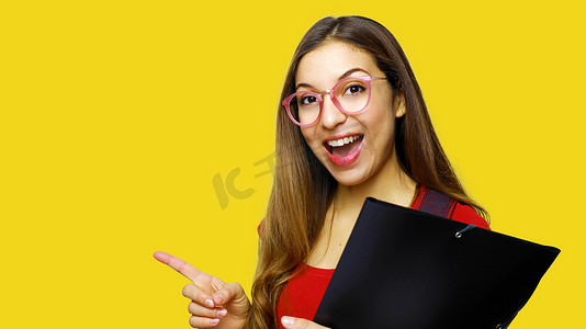 穿着红色 T 恤和书呆子眼镜的漂亮长发女学生的画像，用食指指着复制空间，对着镜头微笑。