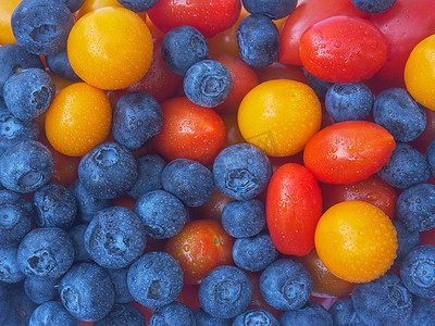 混合浆果食品背景蓝莓的特写质地与黄角醋栗和红樱桃番茄