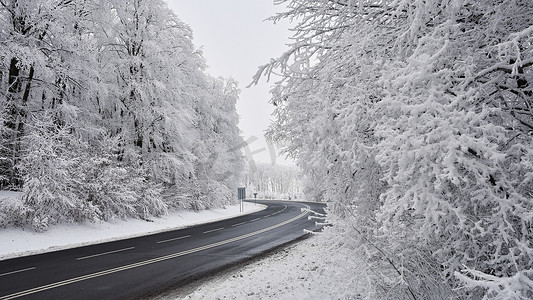 下雪路摄影照片_有积雪的风景的空的路。
