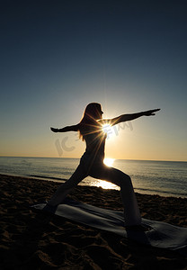 瑜伽摄影照片_海滩上的战士 II 瑜伽姿势