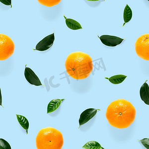 橘色蓝色摄影照片_普通话无缝图案，橘子，克莱门汀在蓝色背景上与绿叶隔离。