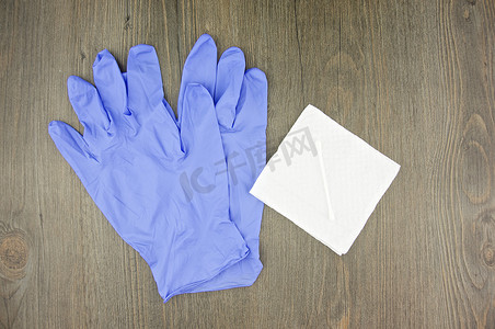 乳胶棉摄影照片_薄纸上的紫色乳胶手套和棉签