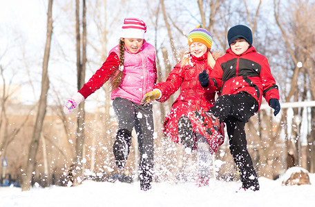 男孩和女孩在冬季公园玩雪