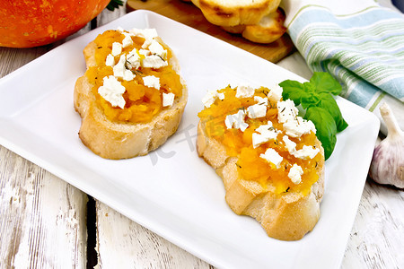 灯板上的盘子里有南瓜和奶酪的意式烤面包