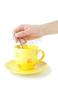 勺子黄色摄影照片_白色背景中突显的黄色咖啡杯，手持勺子
