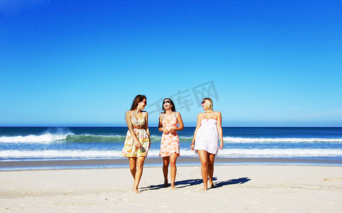 三名年轻女子在夏日的沙滩上玩乐