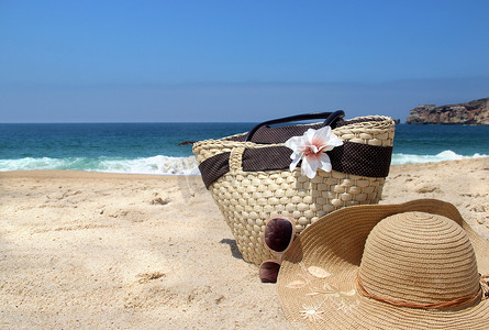 草编摄影照片_“海岸、草编沙滩包、帽子和太阳镜”