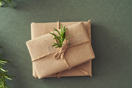 绿纸背景上用生态再生纸包裹的圣诞礼物