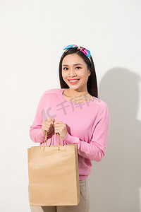 特写肖像年轻漂亮迷人的女孩微笑着带着棕色的购物袋。