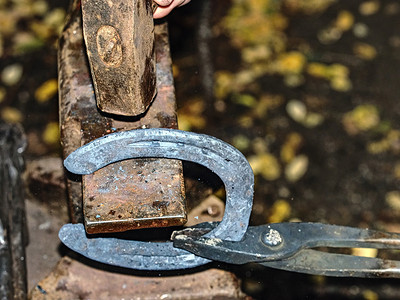 铁匠在铁砧上工作，制作马蹄铁
