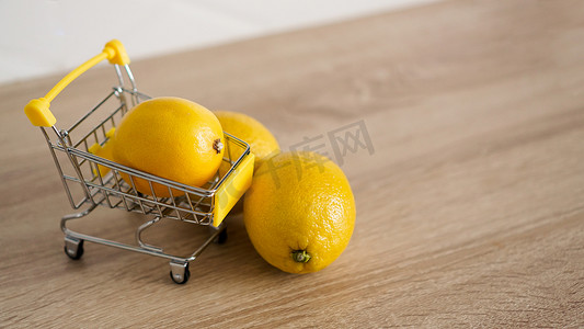 在厨房背景的超市推车中的柠檬。