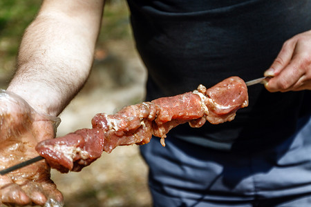 男人把肉串在串上。