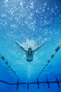 泳帽摄影照片_一个年轻人在水下游泳的低视角