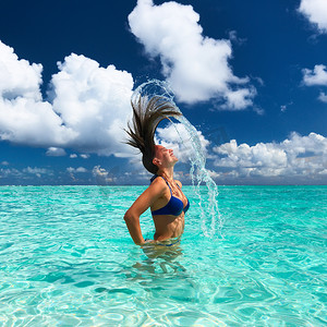 女人用头发在海洋中泼水