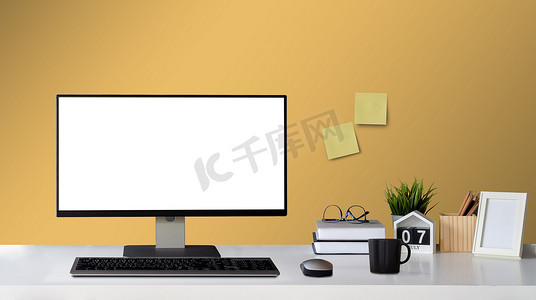 室内展示样机摄影照片_在 Word Desk 家居装饰上用空白的白色屏幕和办公用品模拟计算机，带有相框工作区和产品展示蒙太奇的复制空间。