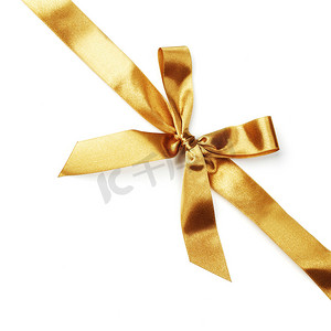 金色的缎带摄影照片_在白色的金色缎带蝴蝶结