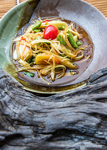 泰国木瓜辣沙拉的特写镜头或在陶瓷盘上称为 som tum。
