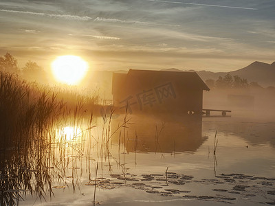 Kochelsee 湖上浪漫的日出倒影与船库的映衬。