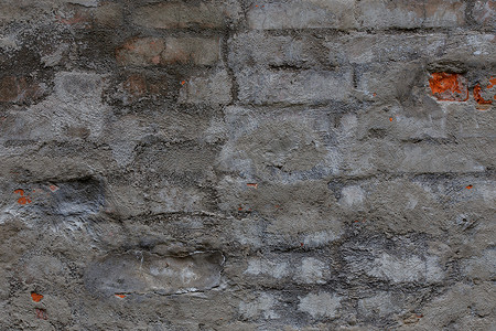 熬制膏药摄影照片_有破旧的灰色水泥膏药层数的老砖墙