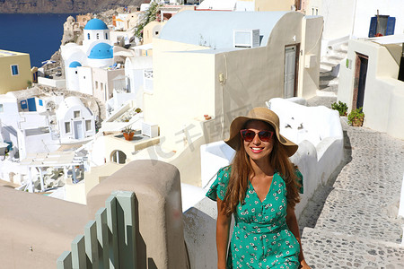 旅游快乐的女人在圣托里尼、基克拉泽斯群岛、希腊、欧洲爬楼梯。