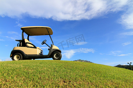 宏伟的摄影照片_“道路上的高尔夫球车，漂亮的绿草和蓝天背景”