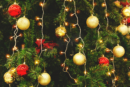 用球、弓和花环装饰的圣诞树有光、背景、纹理