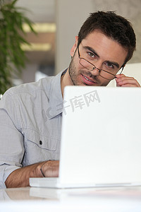 电脑前戴眼镜的男人