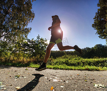 快速奔跑摄影照片_沿着乡间小路快速奔跑的人。