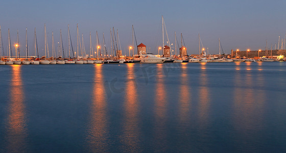 日落时希腊的罗得岛港口和风车