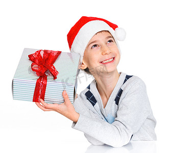 可爱礼物盒子摄影照片_圣诞老人帽子的小男孩有礼物盒的