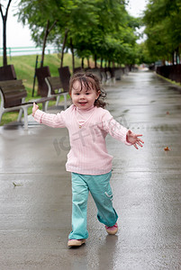 雨后在湿漉漉的大街上奔跑的小女孩
