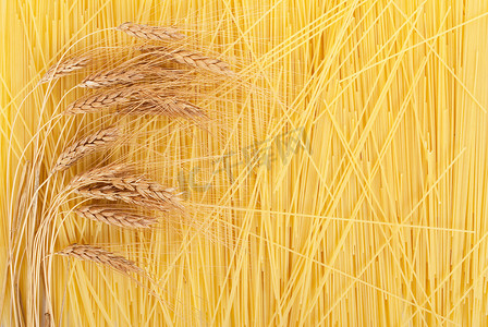 麦穗装饰摄影照片_背景上散落的意大利面条上的麦穗
