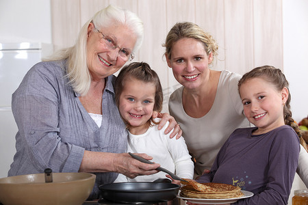 烹调薄煎饼的母亲、祖母和女孩