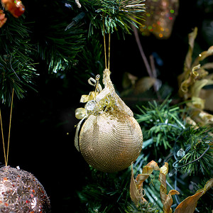 点缀修饰摄影照片_条纹圣诞球，圣诞前夜树在背景中
